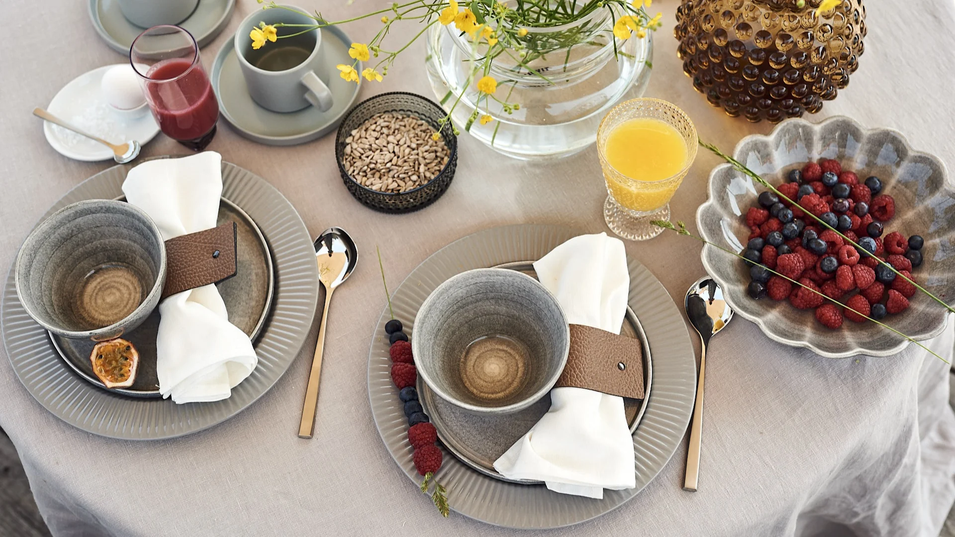 En lyxig och mysig frukostdukning för hotellfrukost hemma med skålar från Mateus och tallrikar från Eva Solo med juice och bär på bordet.