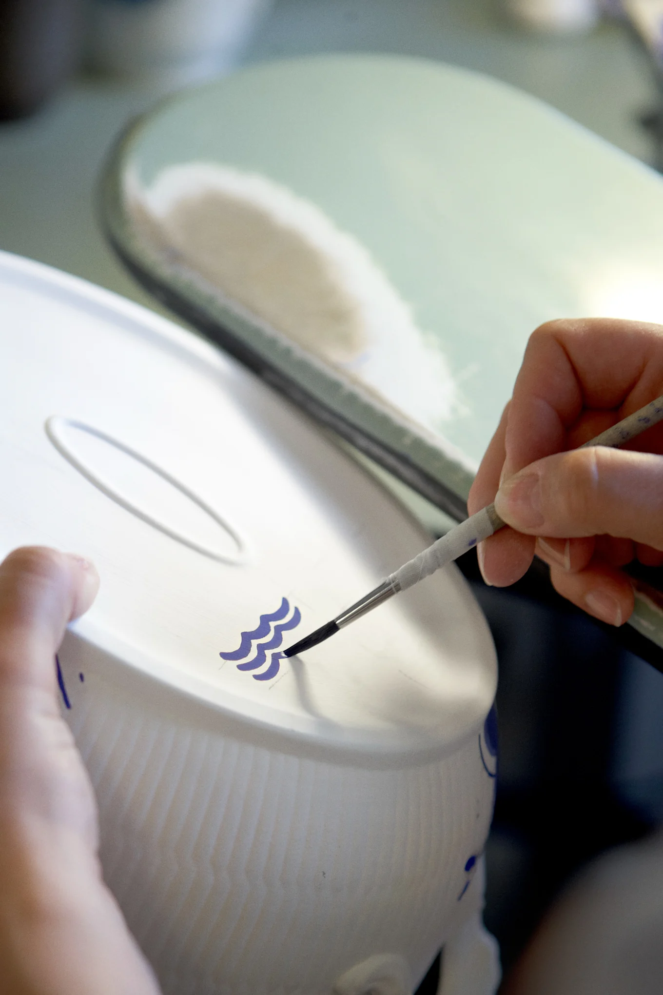 Målningsprocessen av de tre blå vågorna är en signatur på varje porslin från Royal Copenhagen.