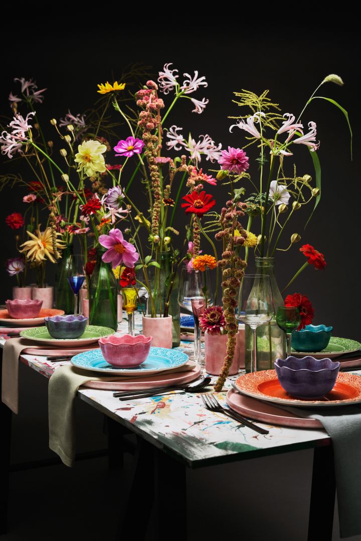 En av höstens inredningstrender 2022 är att skapa extravaganta bordsdukningar till festen! Här en storstilad dukning hos Mateus med blommor i olika höjder. 