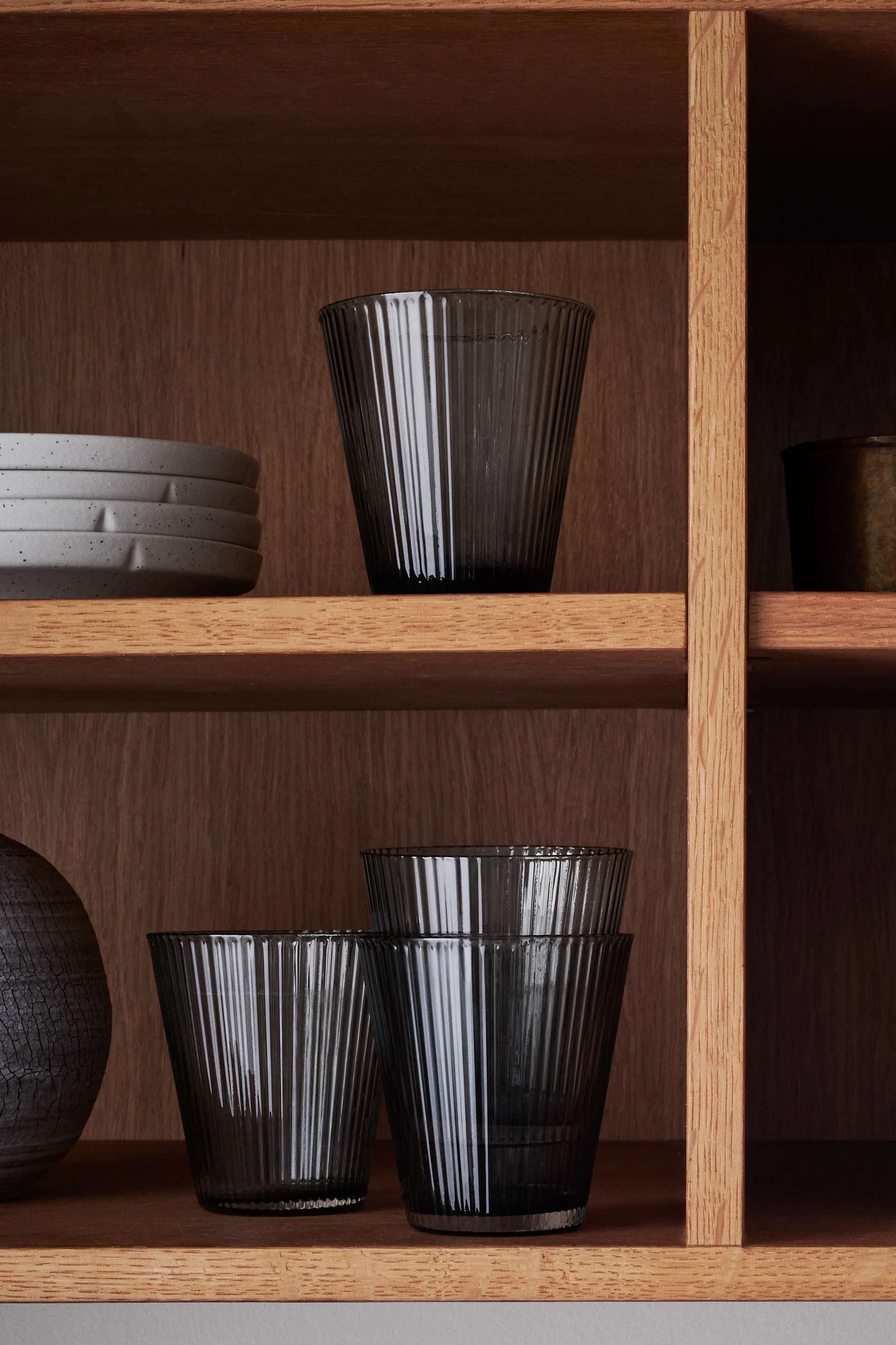 Inredning i räfflat glas är en av årets trender där Grand Cru vattenglas från Rosendahl blir en stilren detalj i vitrinskåpet med dess gråa nyans.