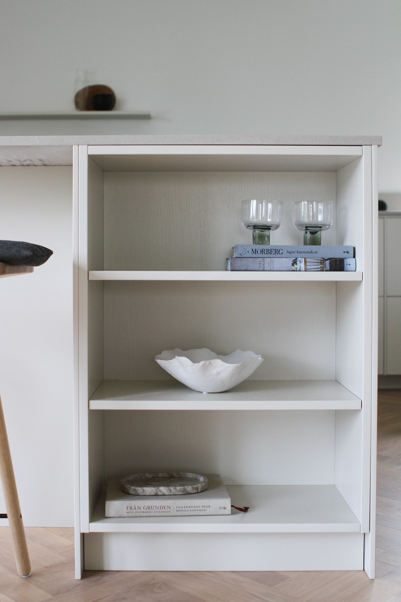 Öppet skåp i nyrenoverade köksön med glas, böcker och en skål som Moe of Sweden har inrett.