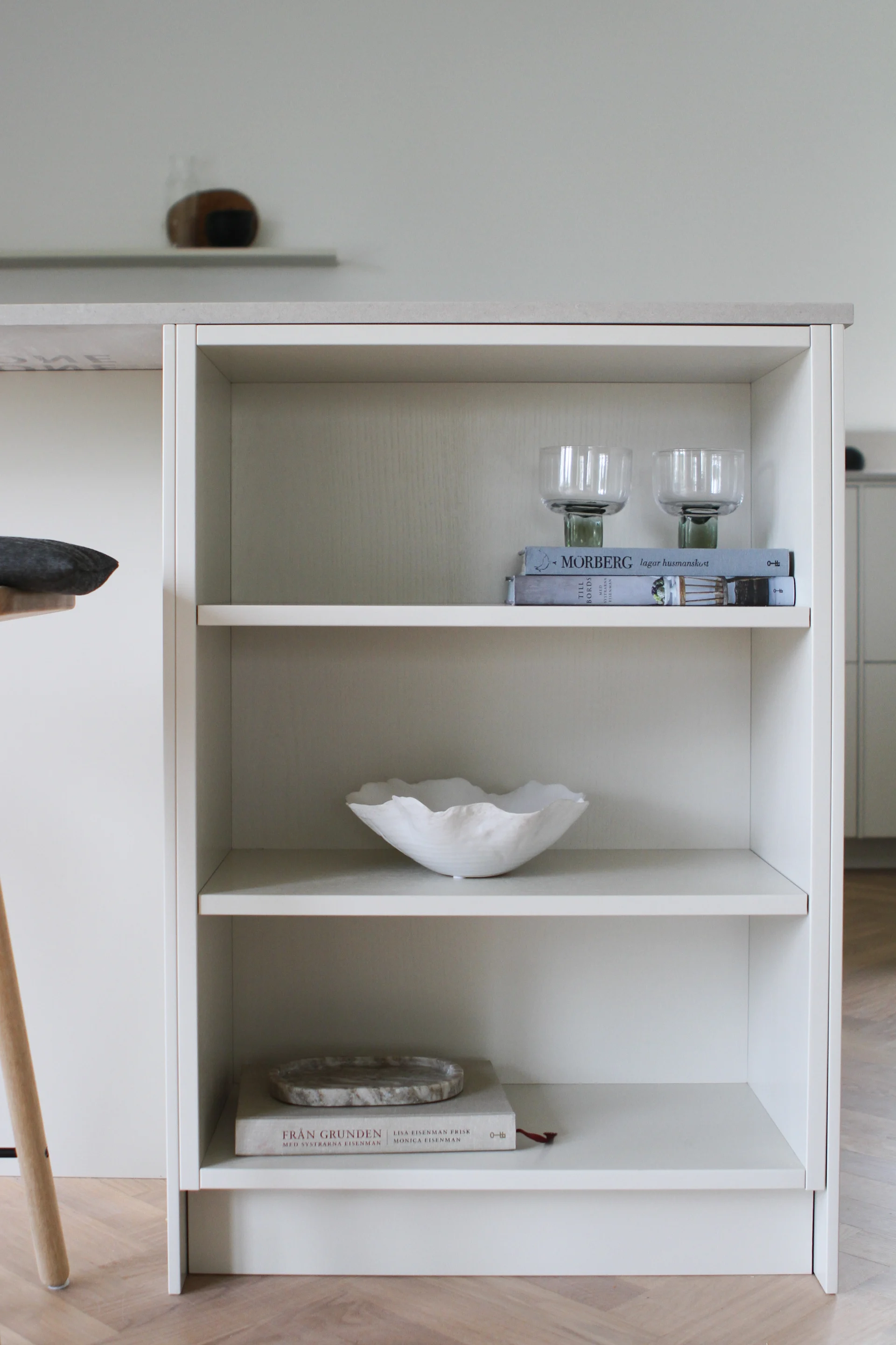 Öppet skåp i nyrenoverade köksön med glas, böcker och en skål som Moe of Sweden har inrett.