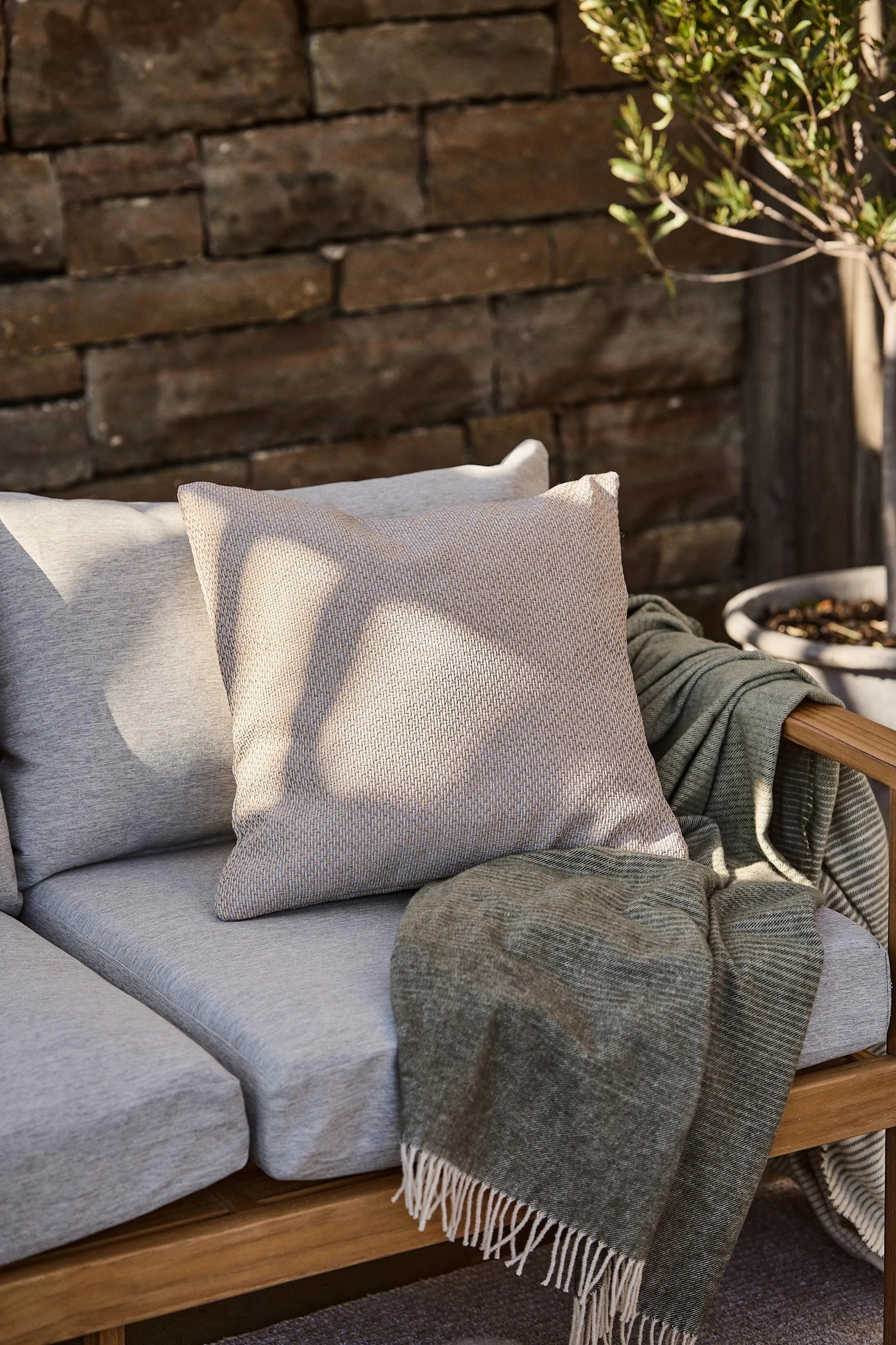 Balkonginspo, kuddar och textilier hjälper dig att skapa en ombonad och mysig balkong samtidigt som du enkelt kan sätta färg på din uteplats, här Asaryd kudde från 1898.