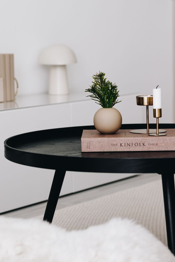Liten rund vas från Cooee Design och ljusstakar i mässing står på soffbordet hemma hos @bythun. 