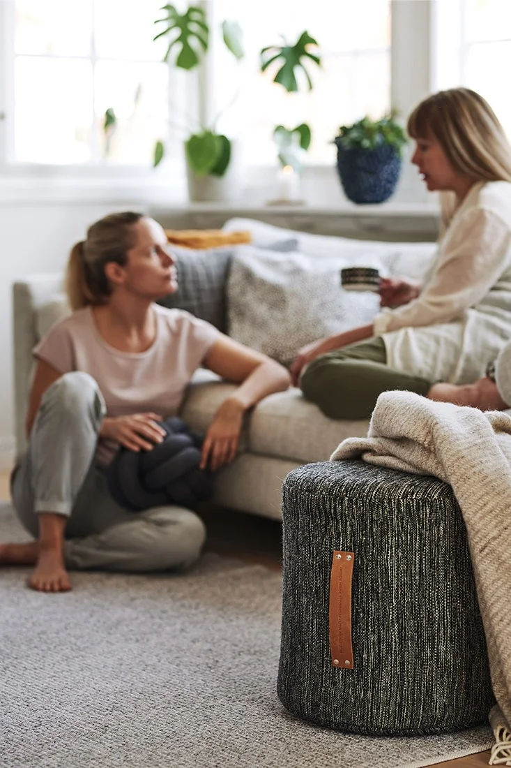 Ett vardagsrum inrett för hygge där mjuka textilier och sköna möbler som sittpuff från Design House Stockholm bjuder in till mysiga stunder.