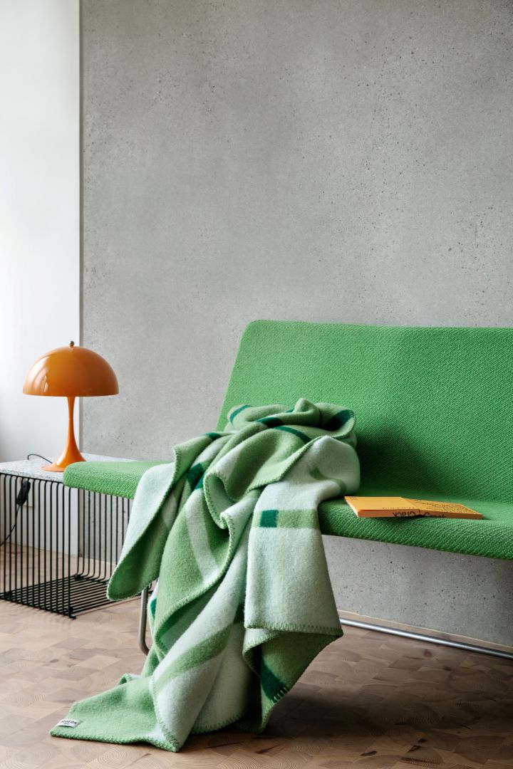 Vårens inredningstrender 2024 bjuder på färg även i textilväg, som denna intensivt gröna filt Knut från Røros Tweed.