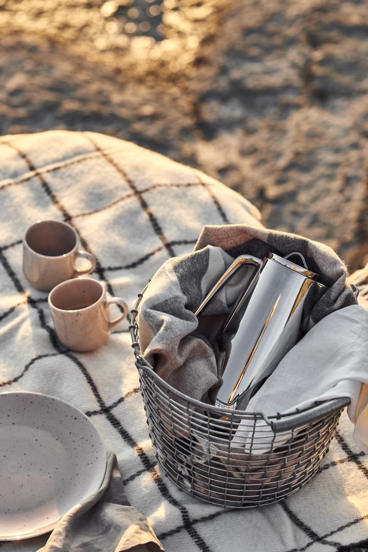 Picknick på stranden med termos redo i stilren Korbo-korg, prickiga muggar på en pläd och prickigt porslin. 