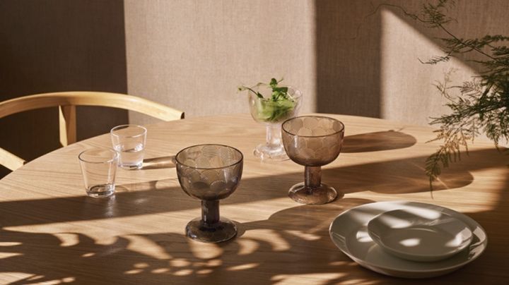 Glas, tallrikar och skålar från Iittala i vackert dagsljus står på bordet. 