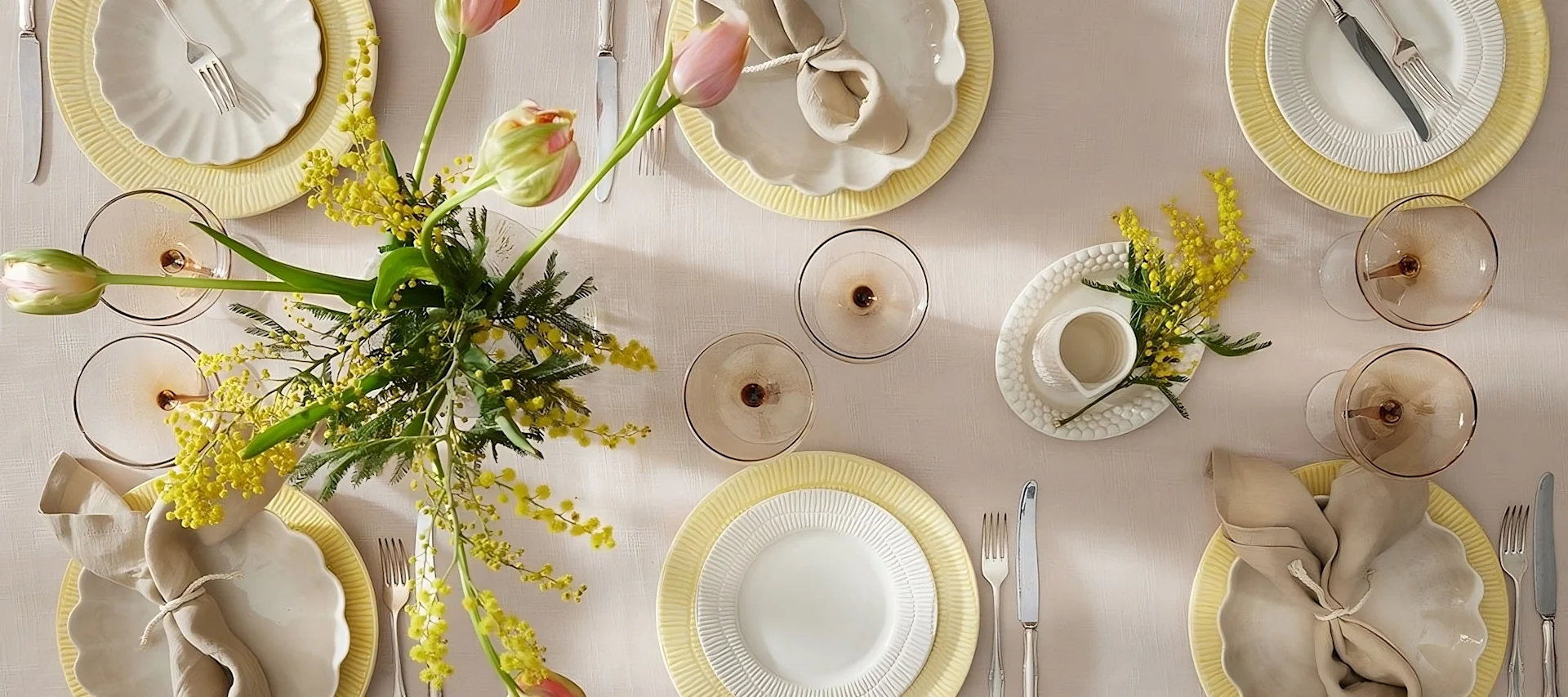 En färgglad bordsdekoration till påsk, bestående av Stripes-tallrikar från Mateus, glas från Byon och servetter från Scandi Living.