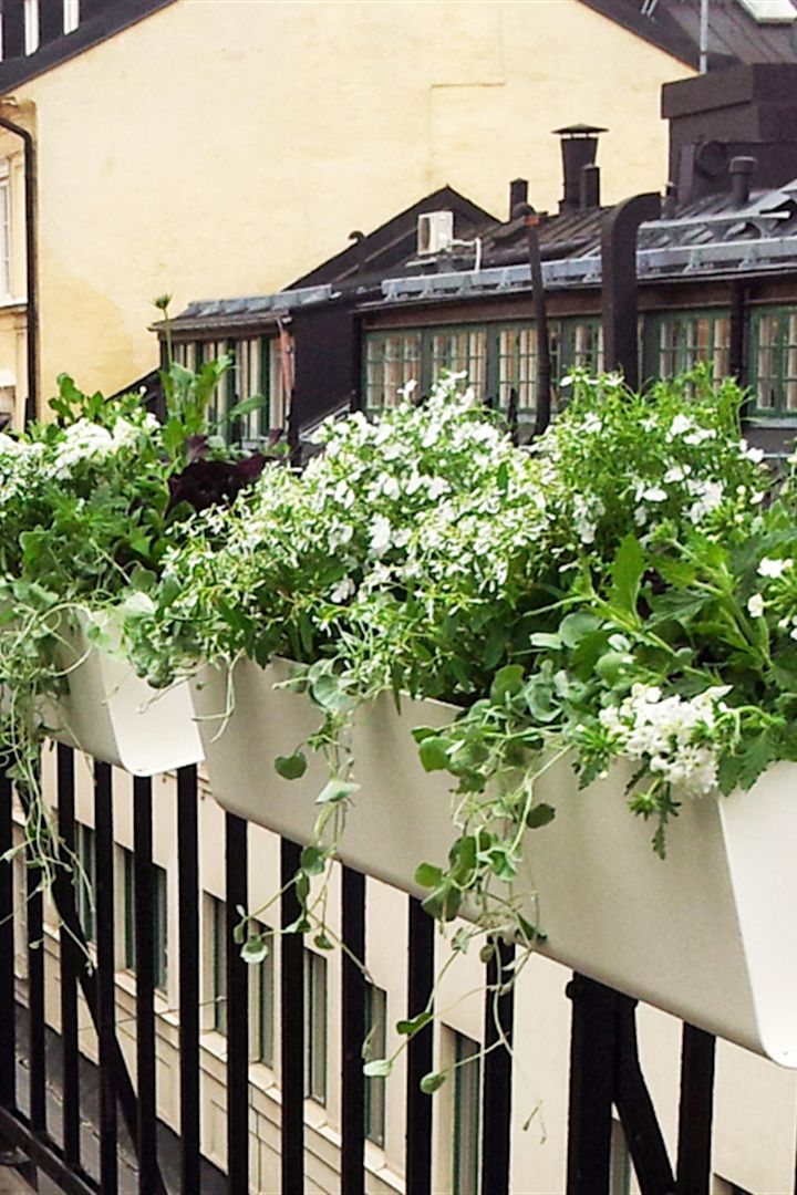Blomlådan Jorda från SDM Design hänger från ett balkongräcke.