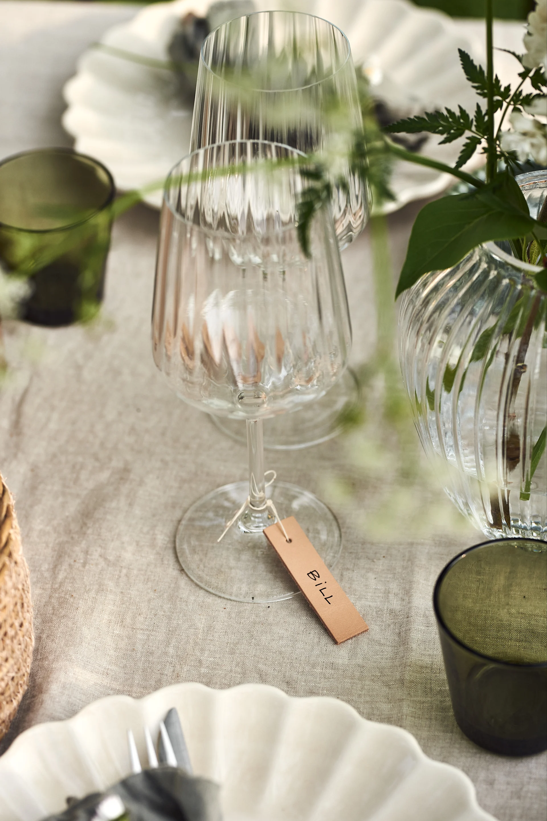 En sommardukning i trädgården är inte komplett utan fina placeringskort. Knyt placeringskorten med ett rustikt snöre runt Lifestyle rödvinsglas från Spiegelau.