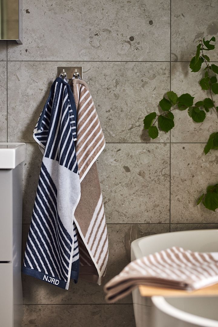 Skapa ett hemmaspa i badrummet genom att inreda med Stripes mjuka handdukar från NJRD i beigt och blått för avkopplande stunder.