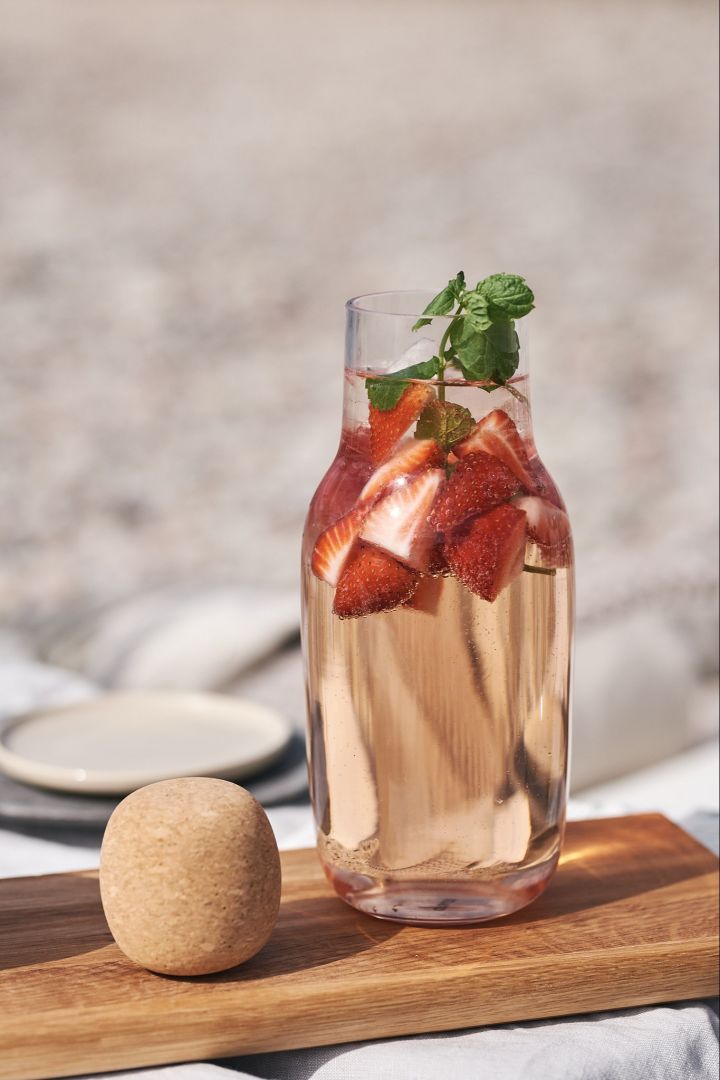 Enkla sommardrinkar – sangria med jordgubbar toppad med mynta serverad i en glaskaraff. 