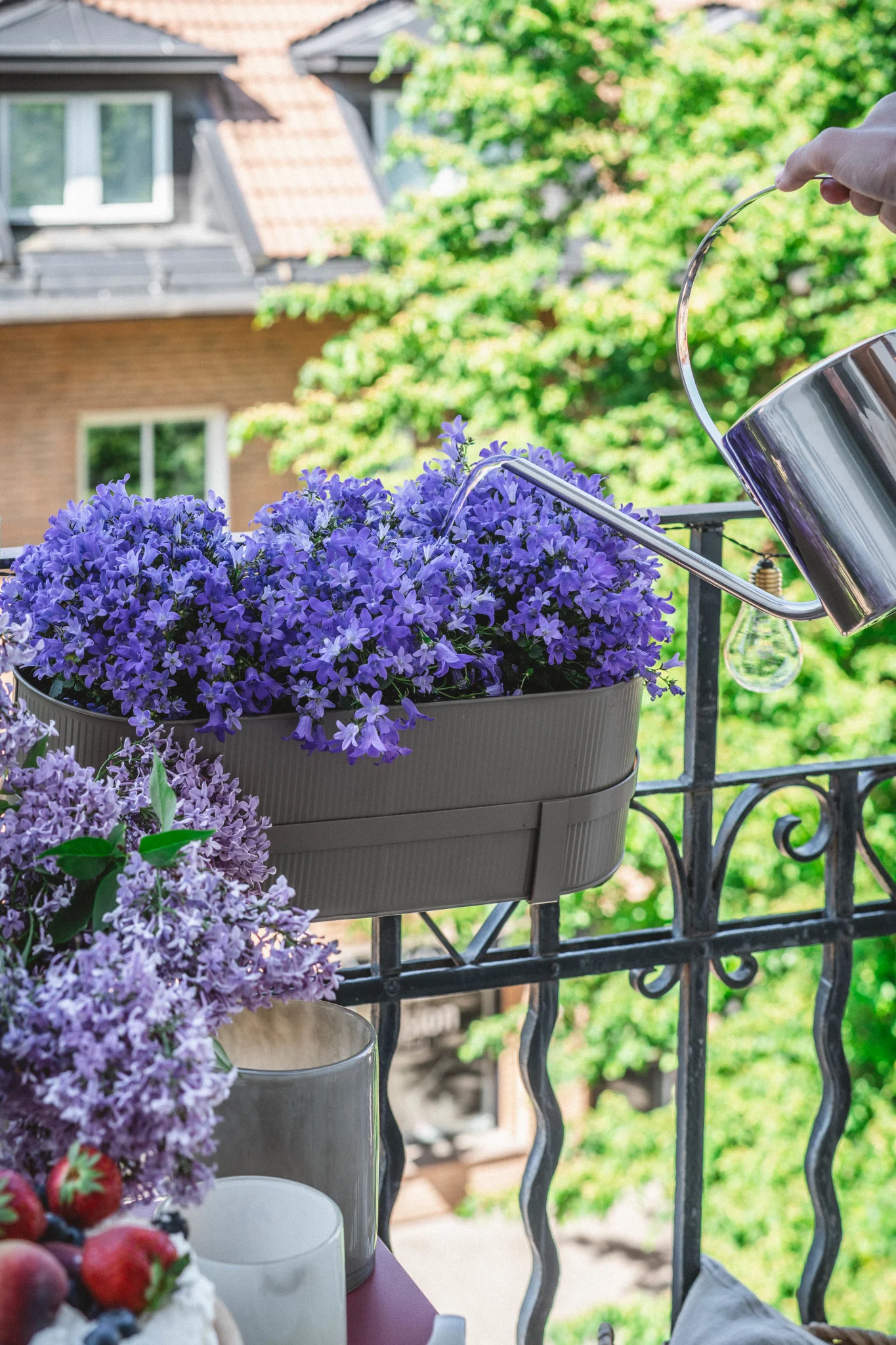 Här kan du se Bau blomkruka i beige från Ferm Living på ett balkongräcke.