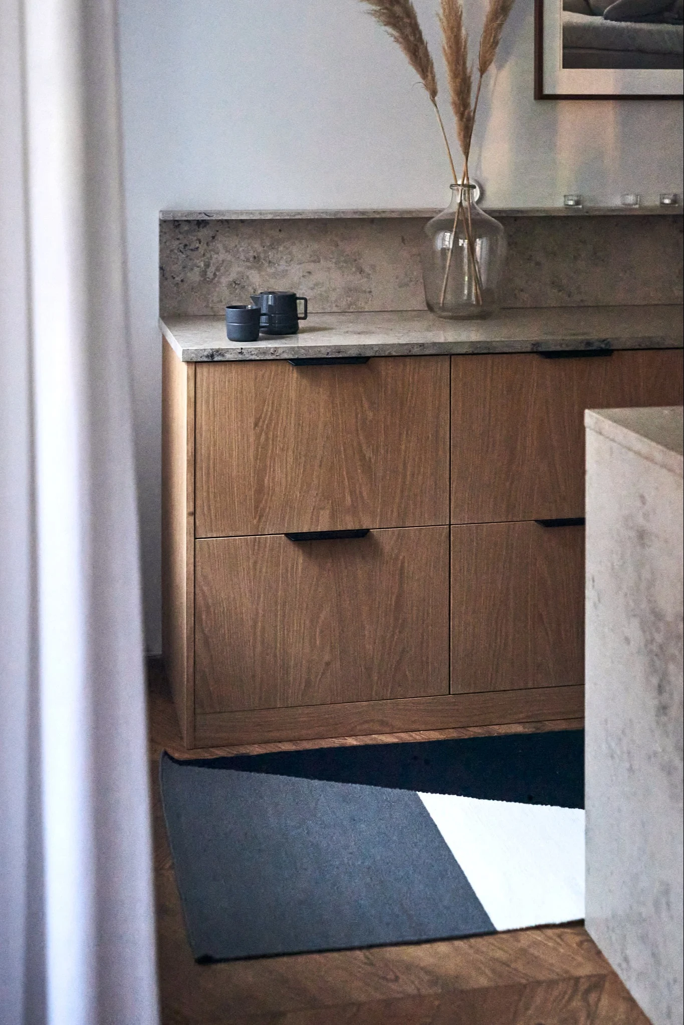 Modernt kök i trä och marmor hemma hos influencern Elin Skoglund med NJRD-matta på golvet.