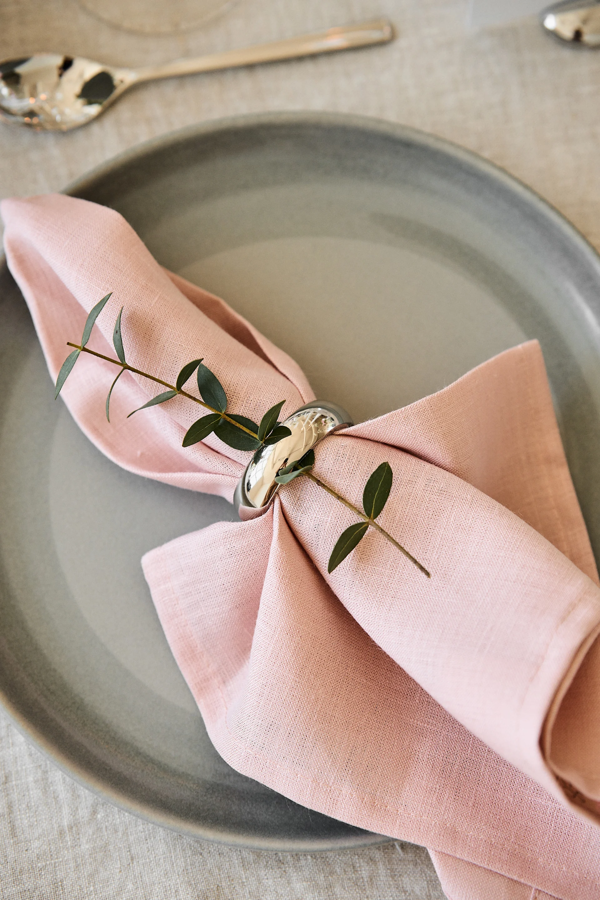 Dekorera bordet för din romantiska måltid hemma i behagliga färger. Här ser du servetten Clean i Dusty Rose från Scandi Living liggandes på en tallrik med en servettring.