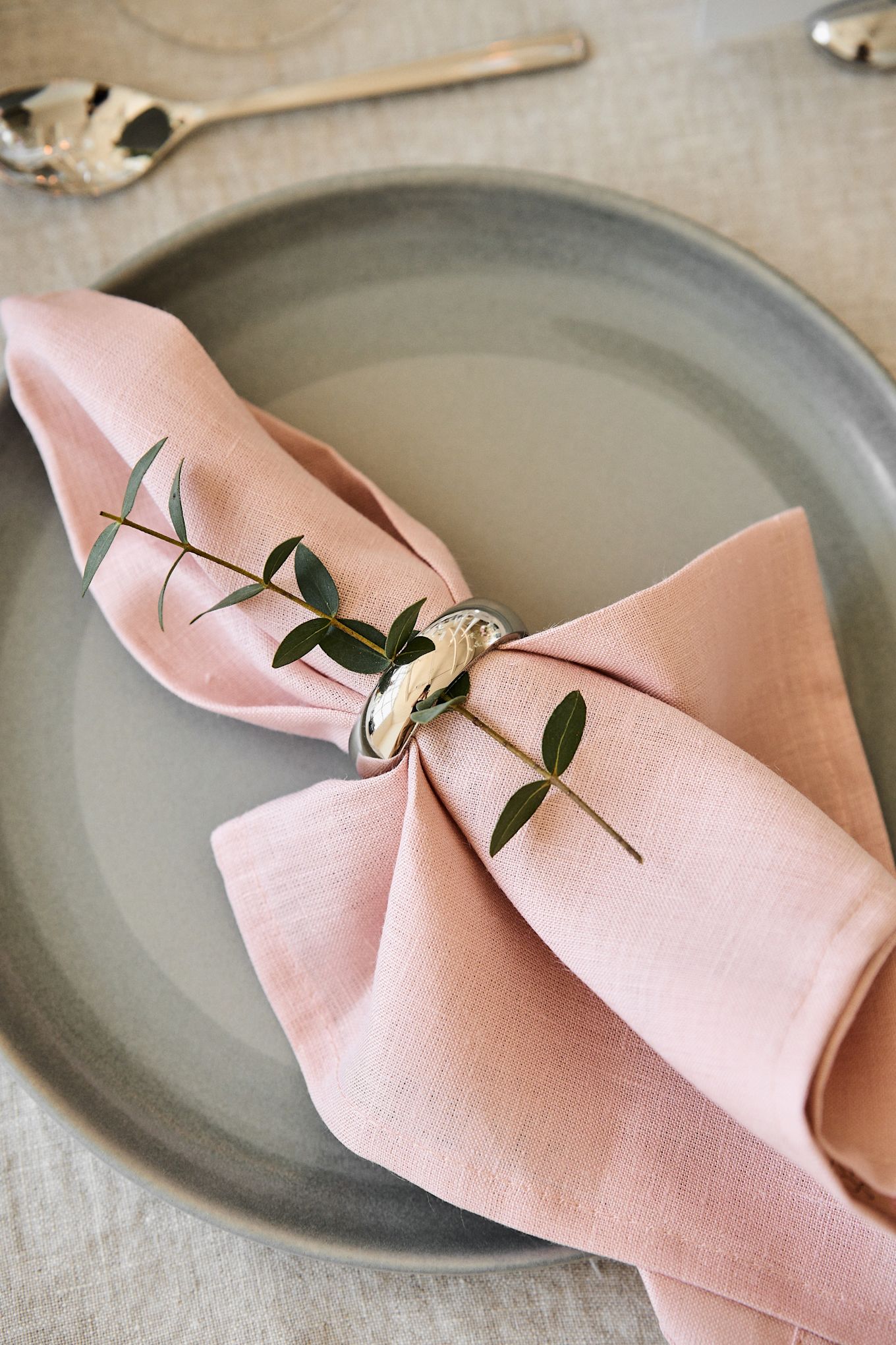 Dekorera bordet för din romantiska måltid hemma i behagliga färger. Här ser du servetten Clean i Dusty Rose från Scandi Living liggandes på en tallrik med en servettring.