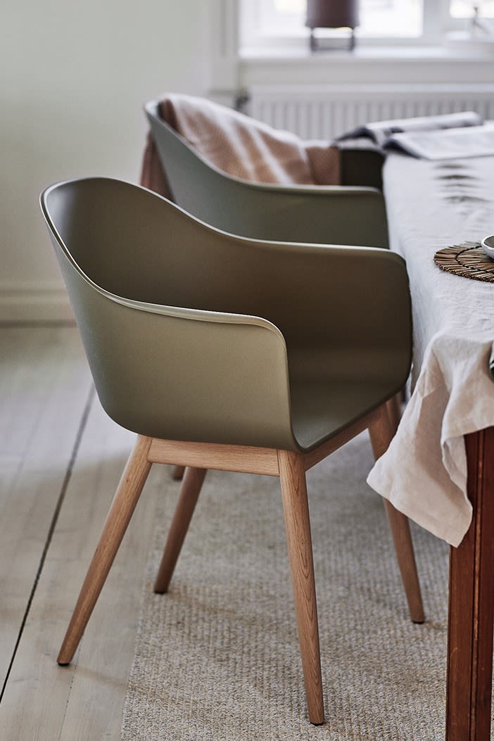 Harbour stol från Muuto i olivgrönt med ek ben skapar värme i en matplats inredd i skandinavisk stil. 