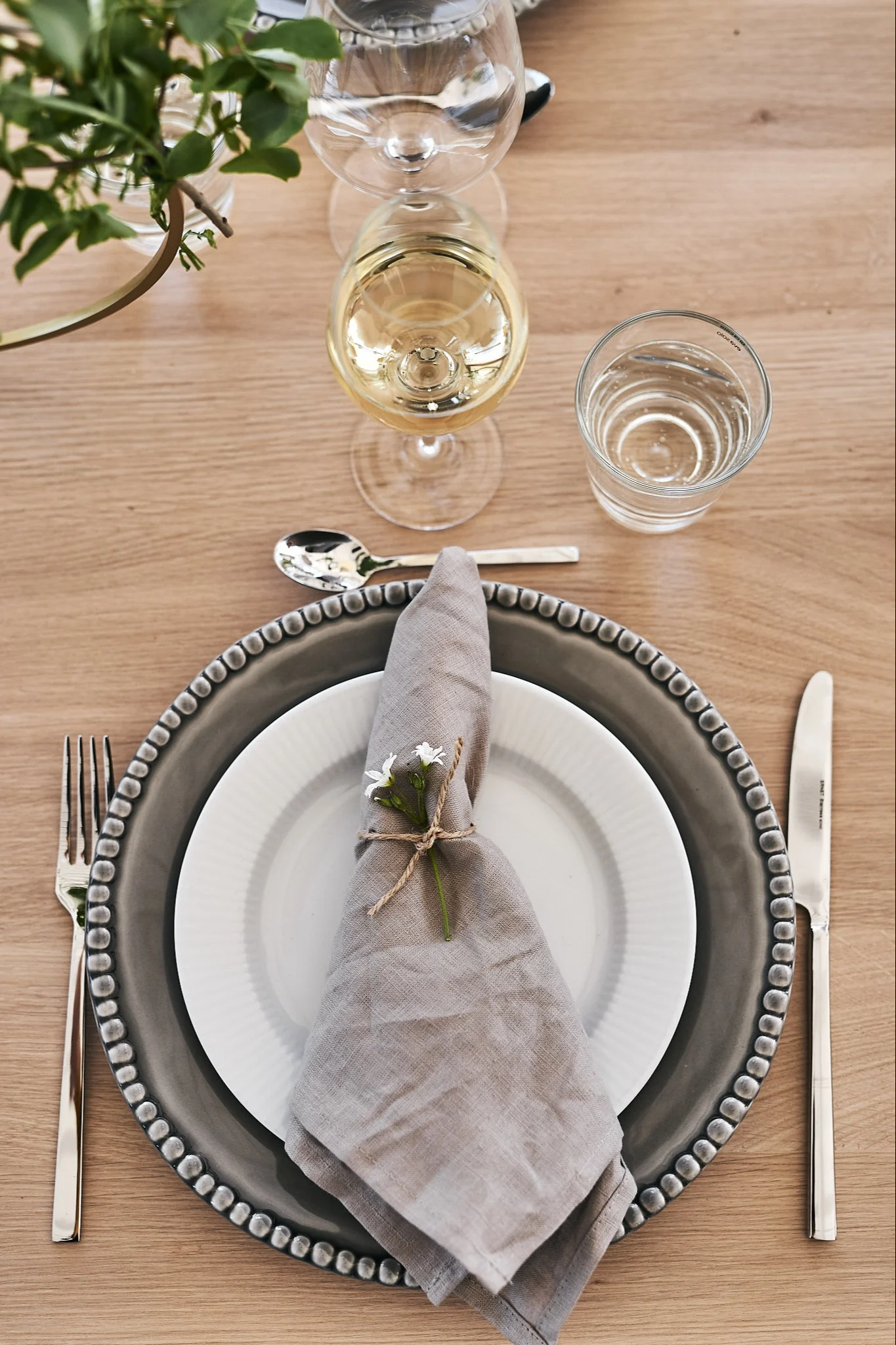 En sommardukning i neutrala färger där porslin från Eva Solo och PotteryJo mixats för en snygg helhet tillsammans med sandfärgad linneservett.