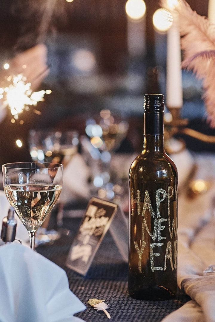 Glitterprydd vinflaska är ett festligt DIY-tips till nyårsfesten. 