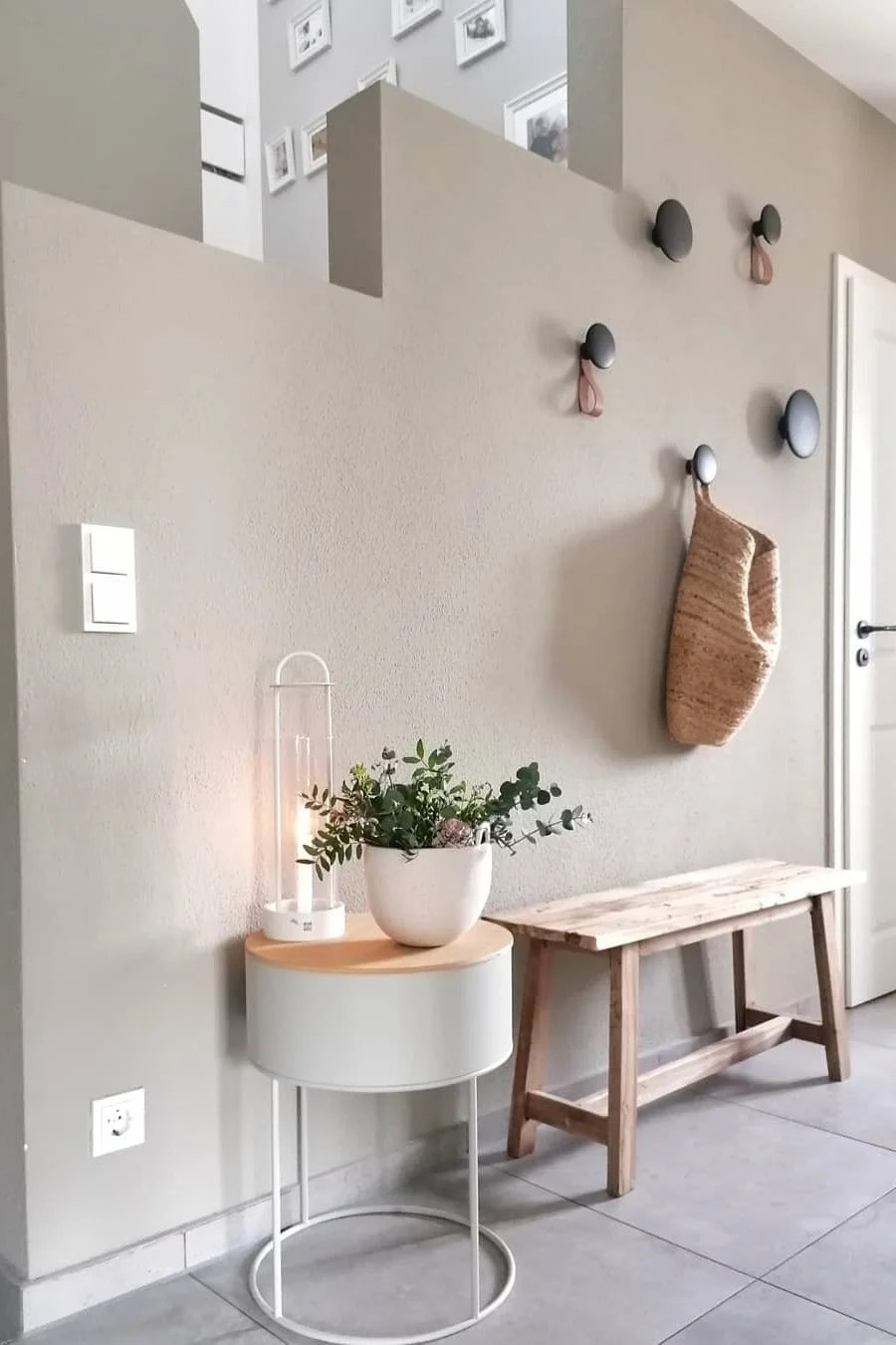 Här kan du se @dani_liveandloves vackert inredda lilla hall med en bänk, krokarna Dots från Muuto och lyktan Lotus från Design House Stockholm.