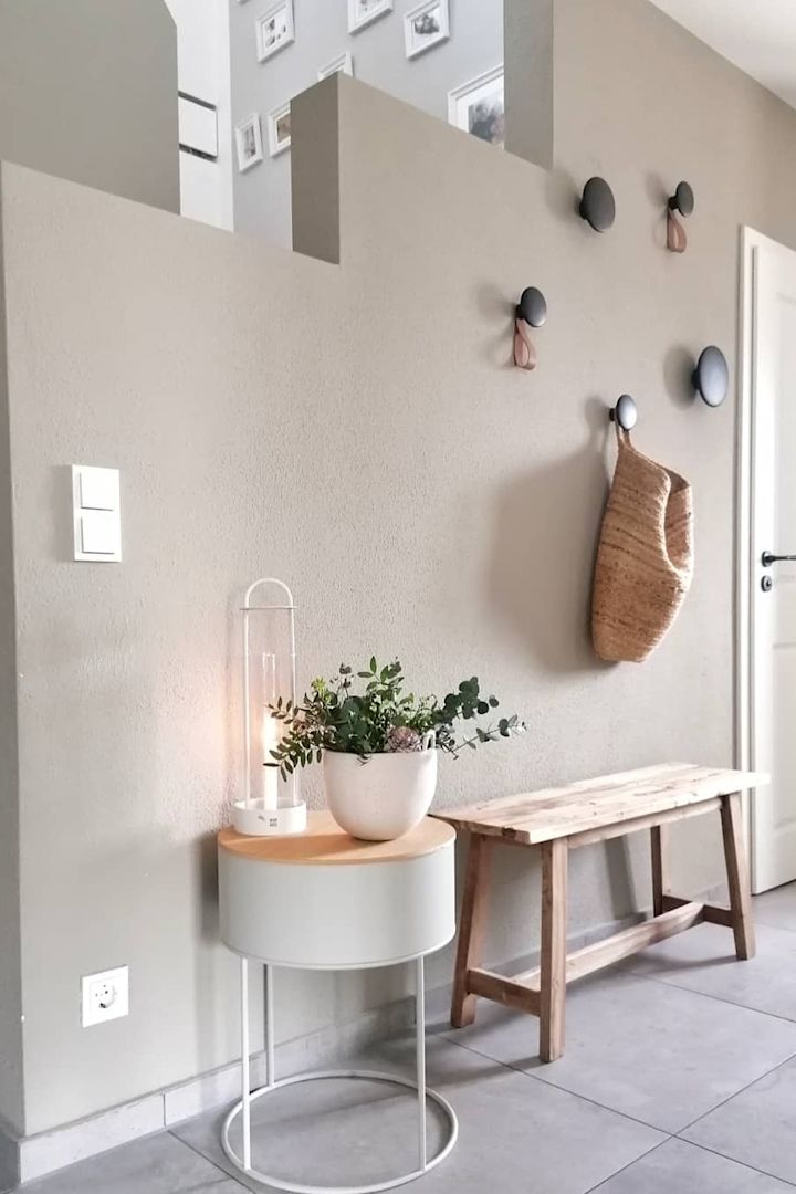 Här kan du se @dani_liveandloves vackert inredda lilla hall med en bänk, krokarna Dots från Muuto och lyktan Lotus från Design House Stockholm.