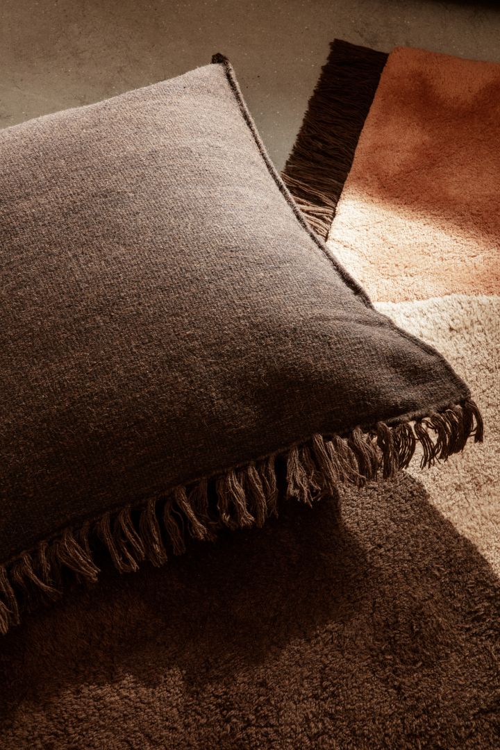 Murriga färger, färgglada textilier tillsammans med mörka träslag är några av höstens inredningstrender 2021. Här är mörkbruna kudden Kelim från Ferm Living på View carpet från Ferm Living i röda och bruna toner.