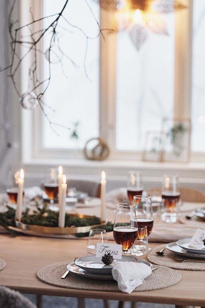 Kottar som placeringskort hälsar gästerna välkomna till bords till årets juldukning som är vit och naturinspirerad. 