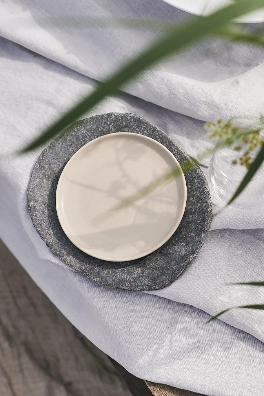 Tåliga tallrikar från Muubs & Marimekko på en vit linneduk är fint att duka med på en lyxig picknick på stranden.