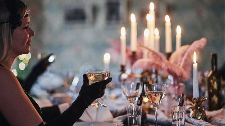 Nyårsdukning i Gatsby-tema där gästen skålar med More champagneglas från Orrefors. 