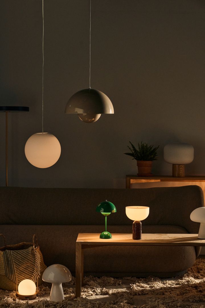 Bild som visar olika lampor i vardagsrum, bland annat Luna taklampa som är en vit klotlampa från Design House Stockholm samt Flowerpot taklampa från &Tradition.