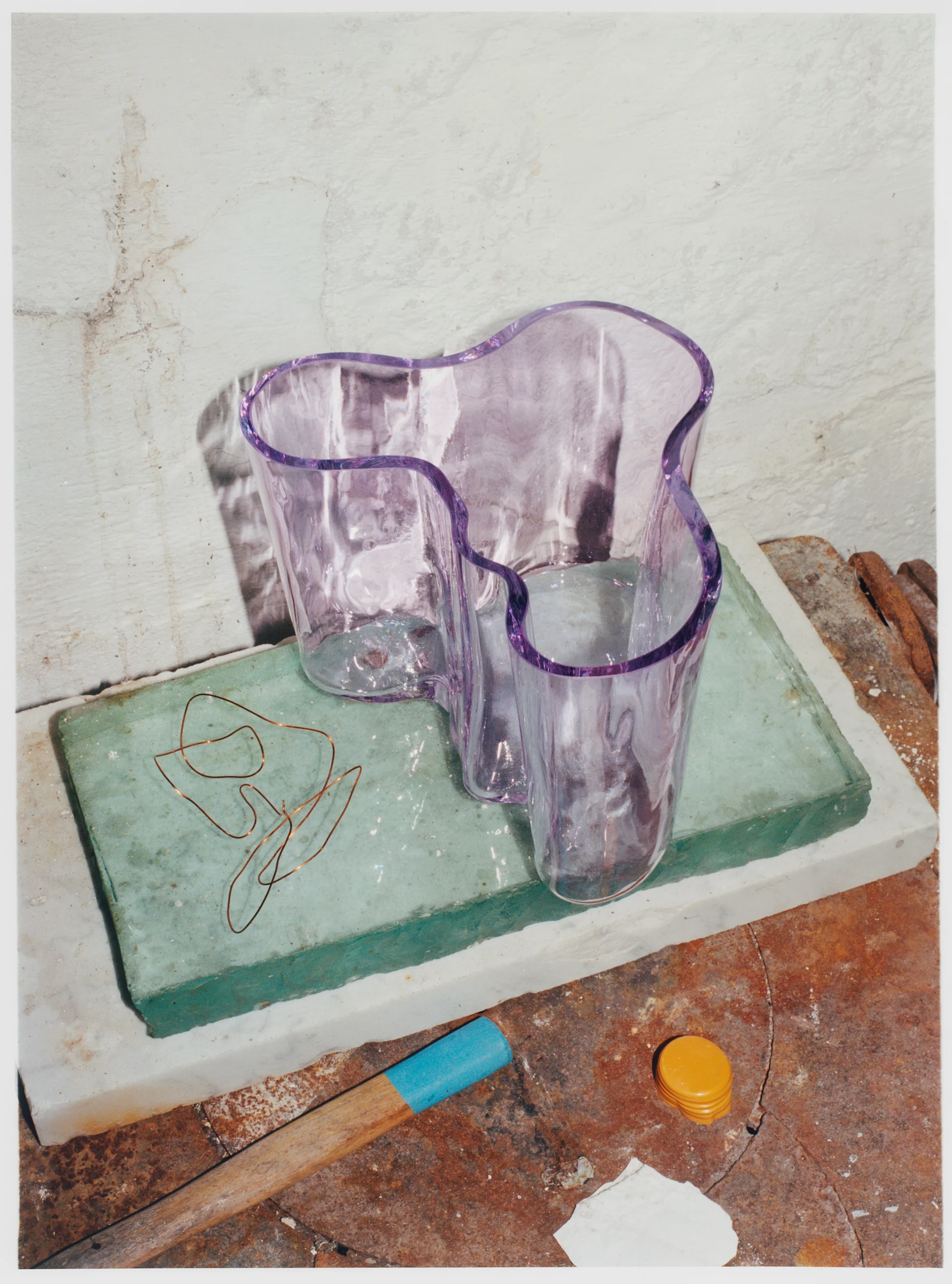 Alvar Aalto-vas från Iittala i en ljuslila nyans stående på stenblock.