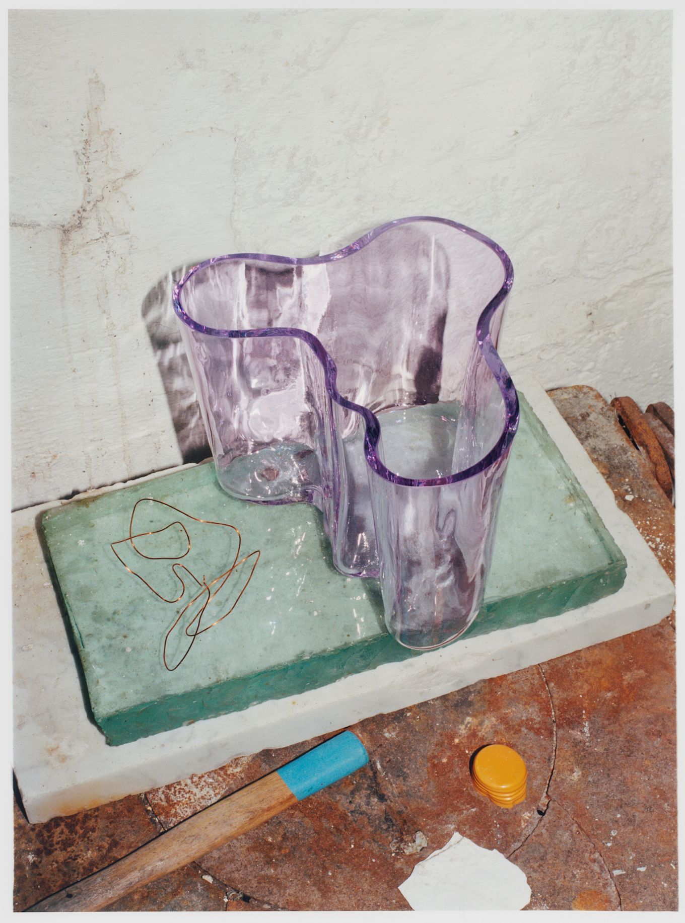 Alvar Aalto-vas från Iittala i en ljuslila nyans stående på stenblock.