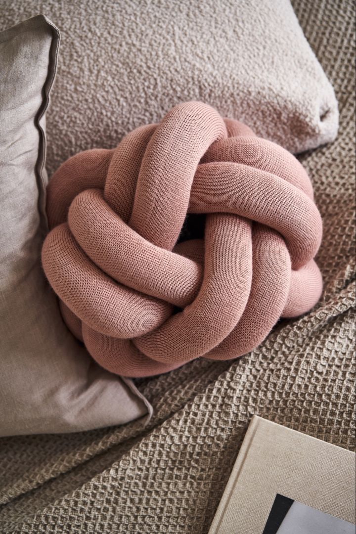 Lilla Knot-kudden i dusty pink på sängen.