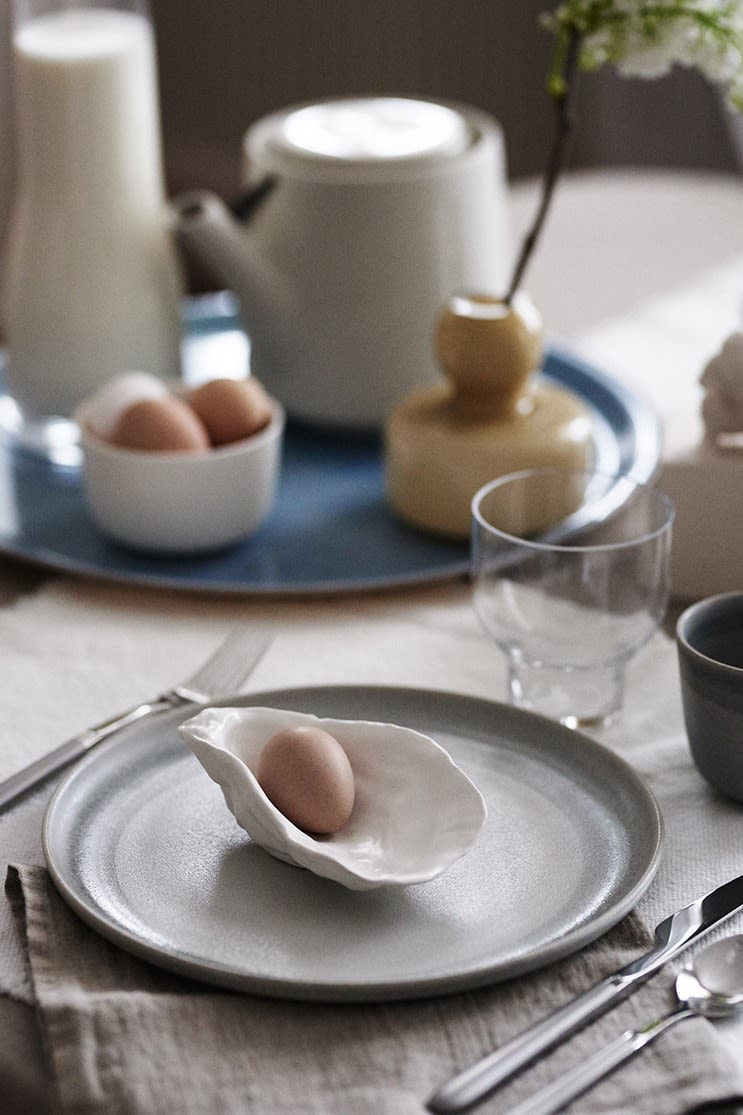 Duka upp till frukost enligt avkopplande inredningstrender med rustik tallrik och ostronformad skål från By On för frukostägget. 