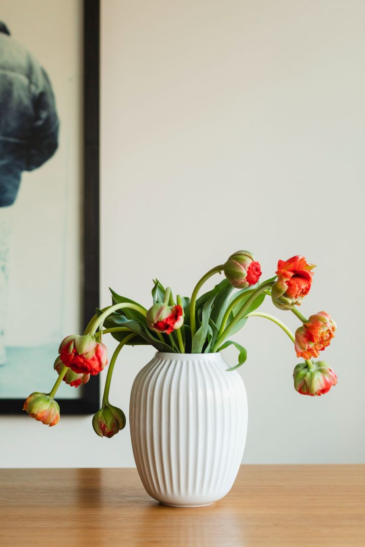 Tidlösa designklassikern Hammershøis vita vas från Kähler hemma hos Ebba Kleberg von Sydow som är fylld med blommor.