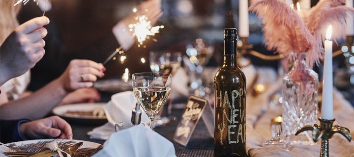 Festliga och roliga tips till nyår och din nyårsdukning: glitterprydd vinflaska och tomtebloss.