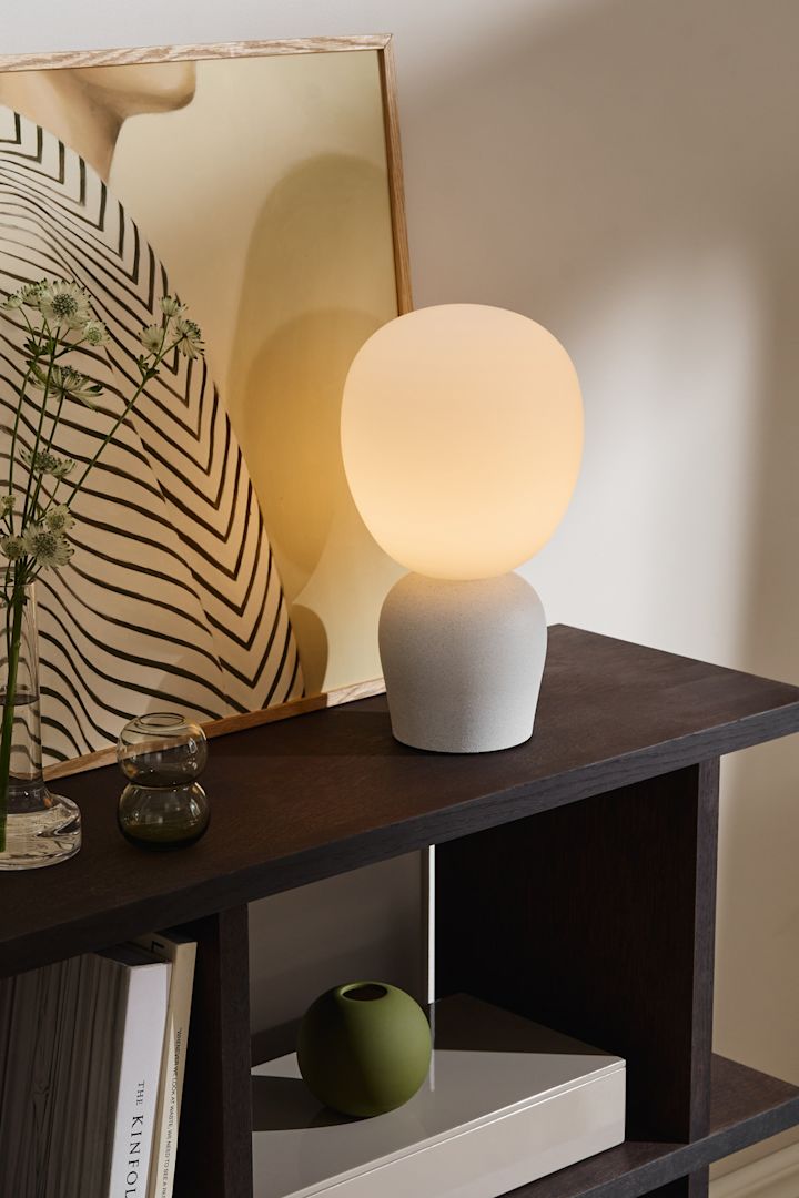 Använd olika lampor som bordslampor, vägglampor och taklampor för att lysa upp din matsal. Här ser du bordslampan Buddy med en lampskärm i frostat glas från Belid. 