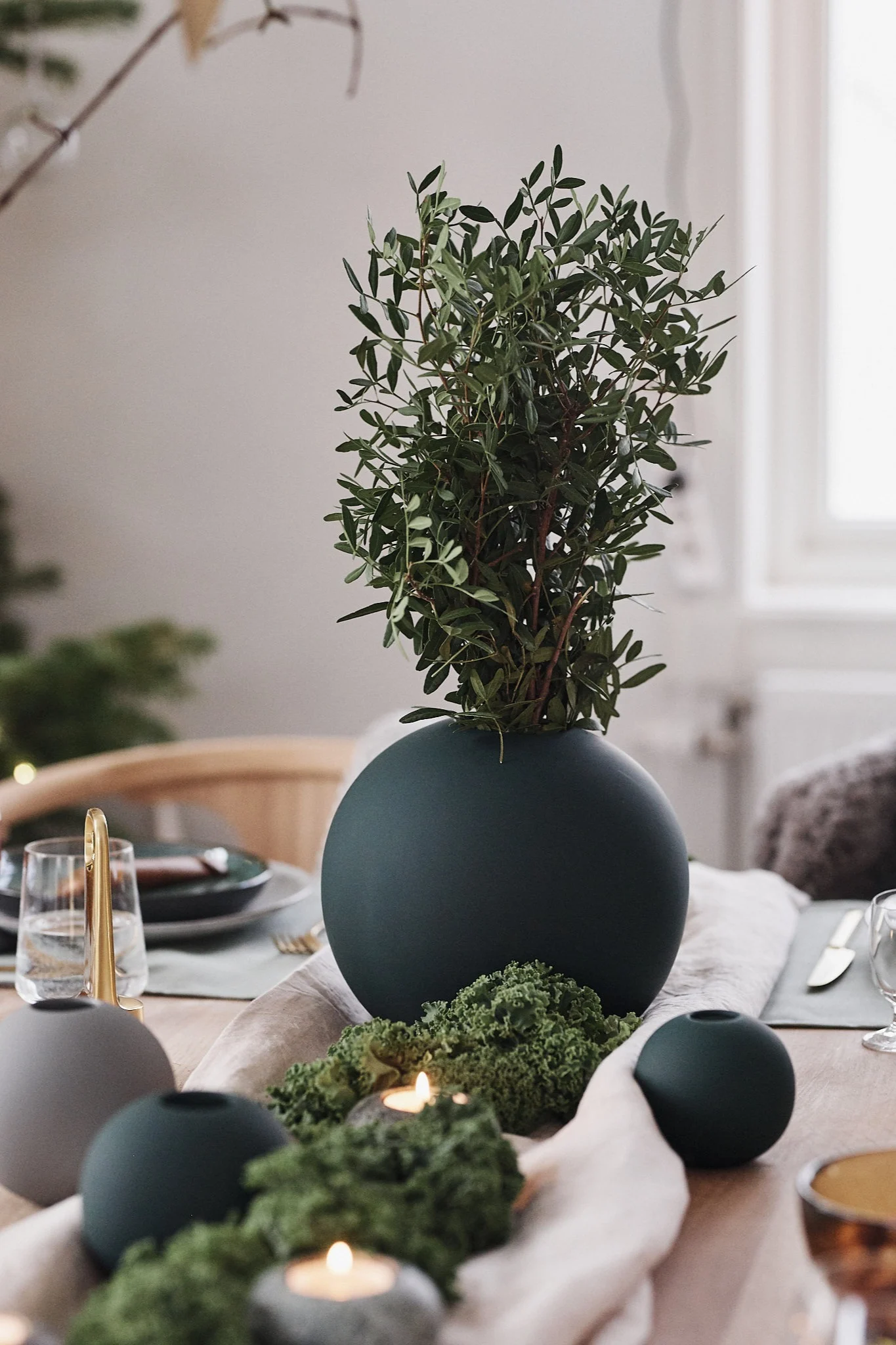 Grön rund vas från Cooee Design pryder juldukningen som går i gröna toner med inspiration hämtad från naturen.