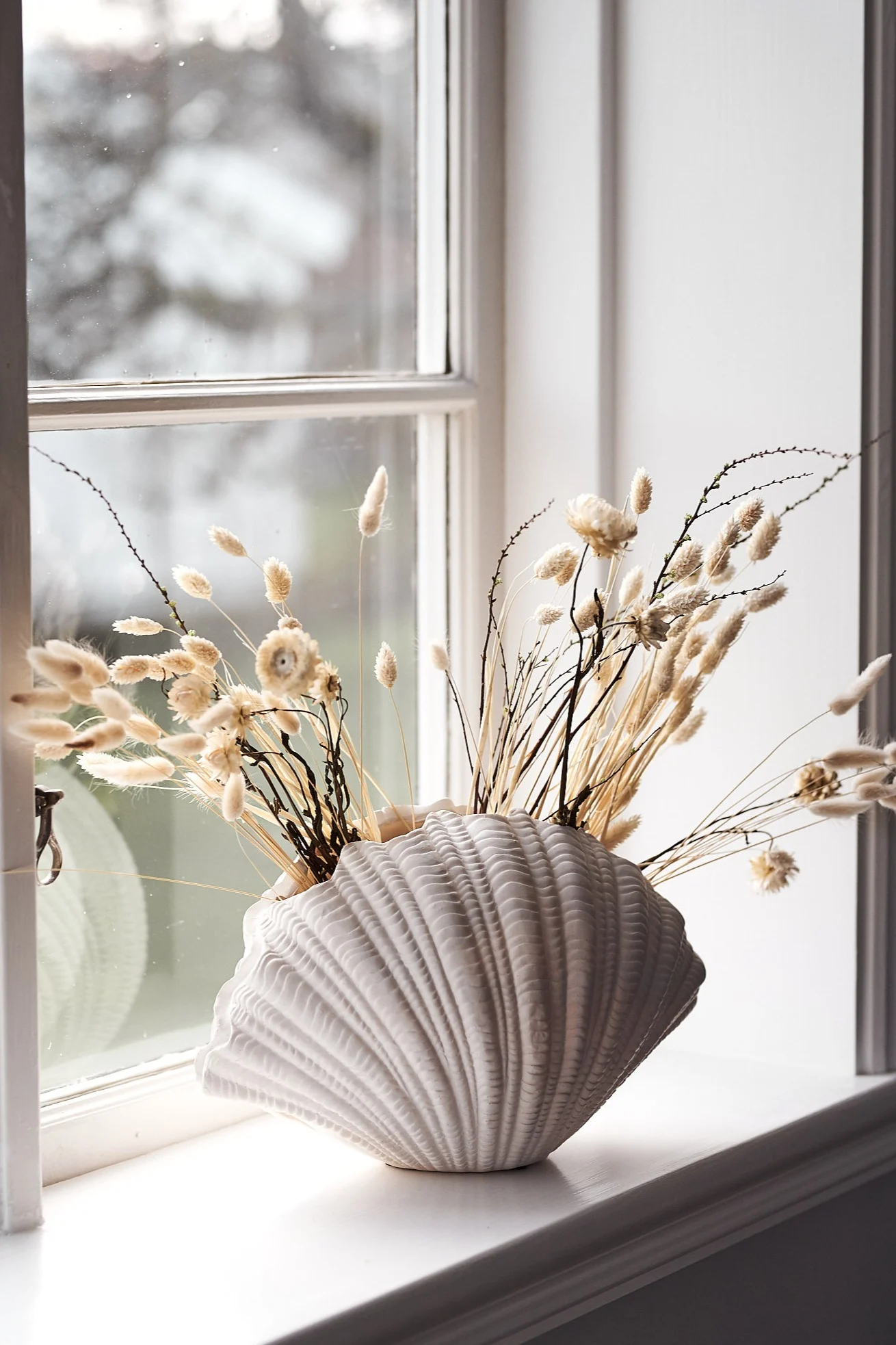 Torkade blommor – inredning som visar Lagurus i snäckformad vas från By On. 