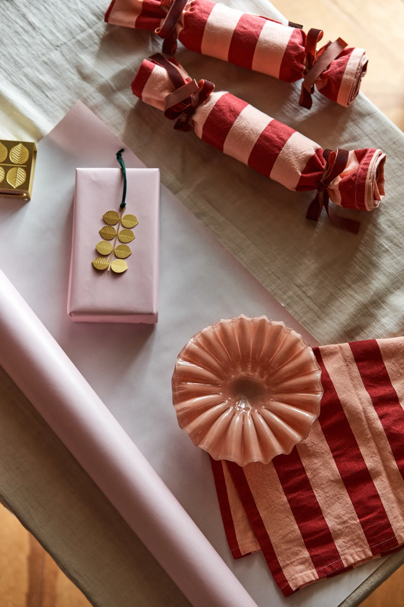 Här väntar en rosa skål från Byon och ett gyllene hänge från Pluto på att bli vackert inslagna i randiga kökshanddukar och rosa papper, ett kreativt sätt att fira första advent.