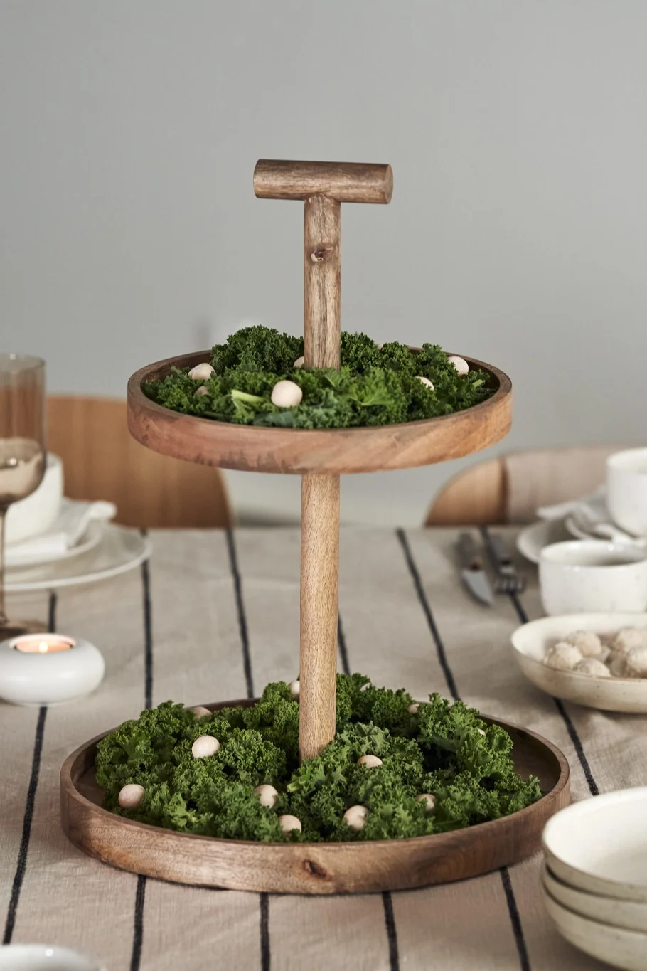 En elegant juldukning i 4 olika stilar enligt Nest Trends; Cultivate, Nurture, Boost och Share. Här är en dukning inom Nurture-trenden med Bloomingville kakfat i trä med mossa i från skogen som dekoration.