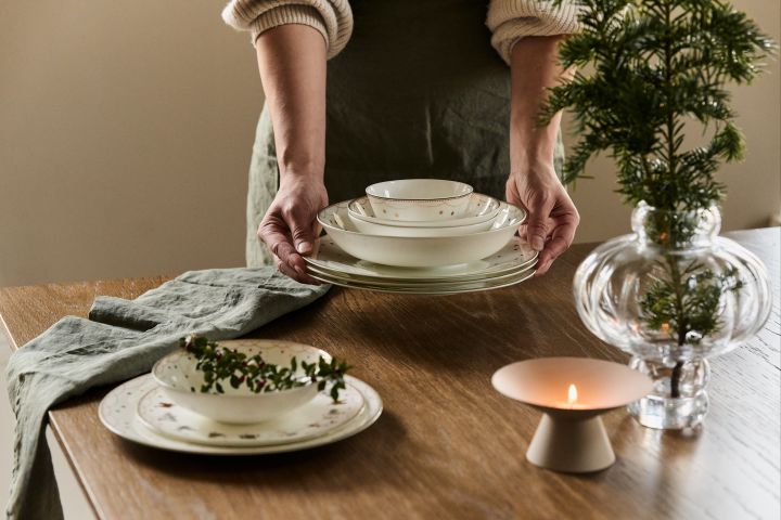 Pynta med granris dekoration på det dukade bordet i till exempel en vas, på tallriken eller i servetten för att skapa julstämning i hemmet.