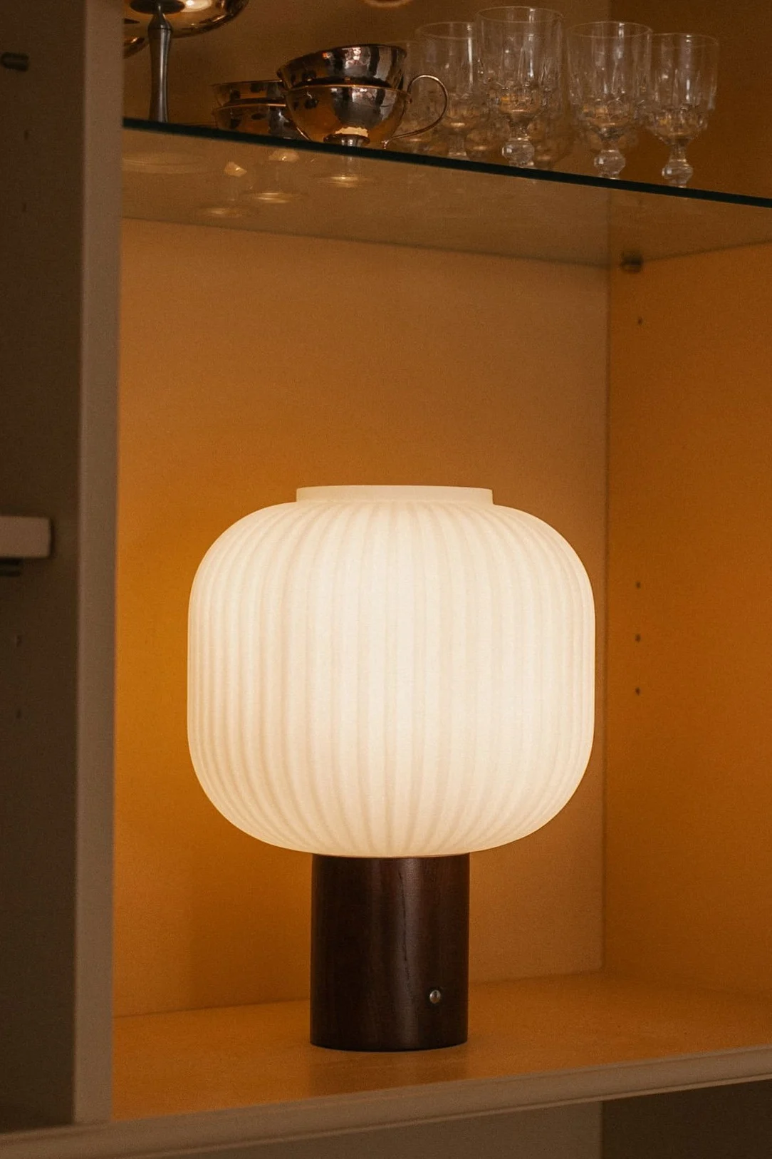 E27 lampa från Muuto med glödlampa med 2500K på ett sidobord.