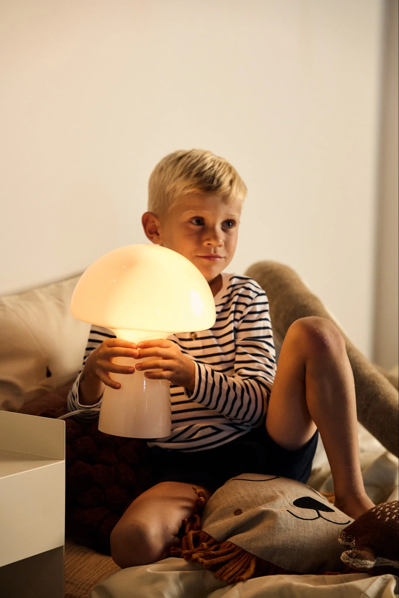 E27 lampa från Muuto med glödlampa med 2500K på ett sidobord.