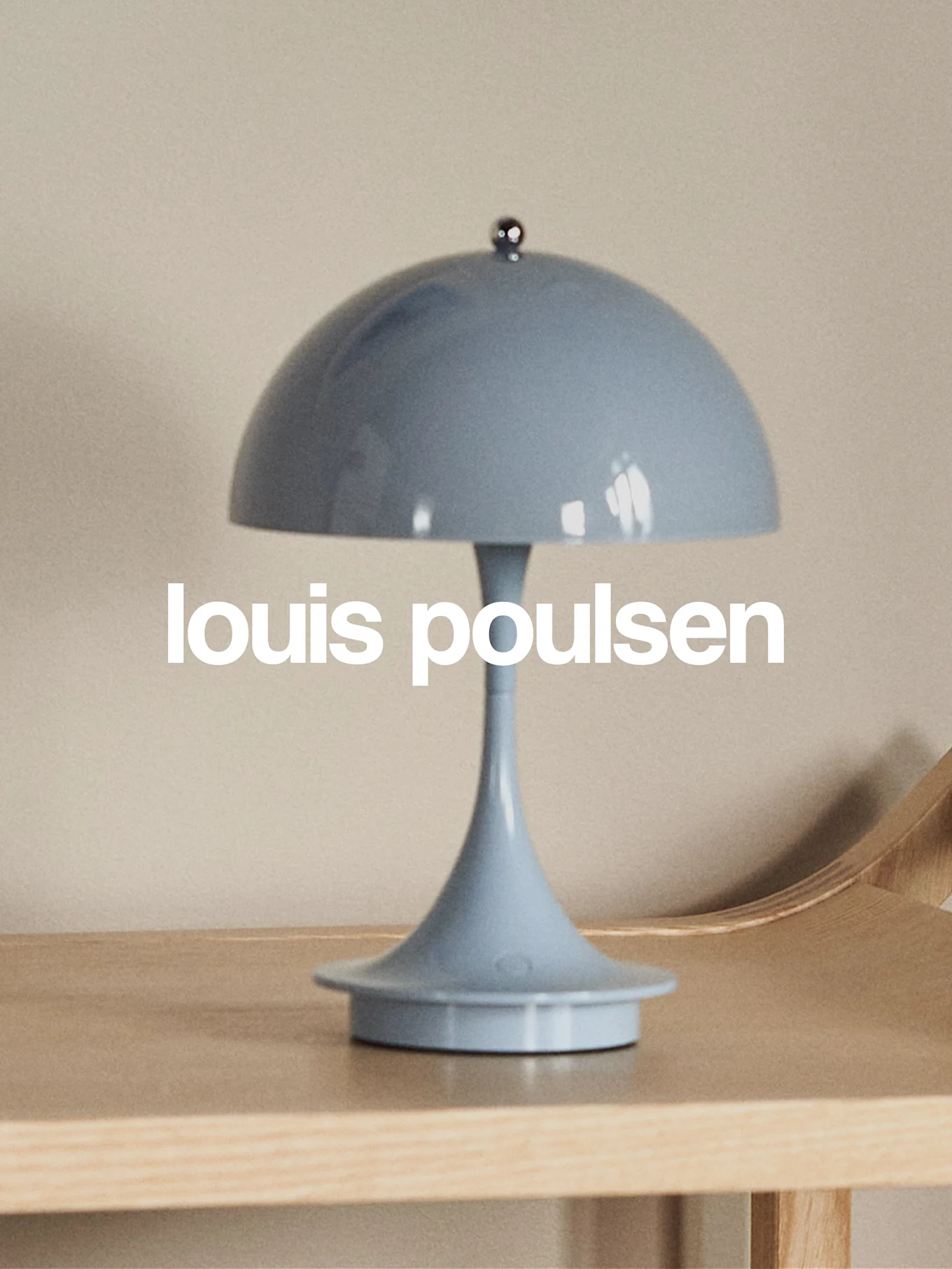 Ljusblå svampformad bordslampa på en träyta med texten 'louis poulsen'.