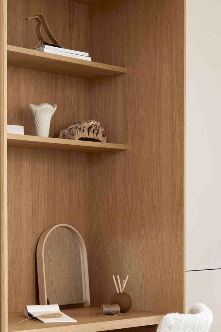 Produkter från Cooee’s kollektion Woody står i en trähylla. På bilden finns Woody fågeln och Woody spegel i ek. 