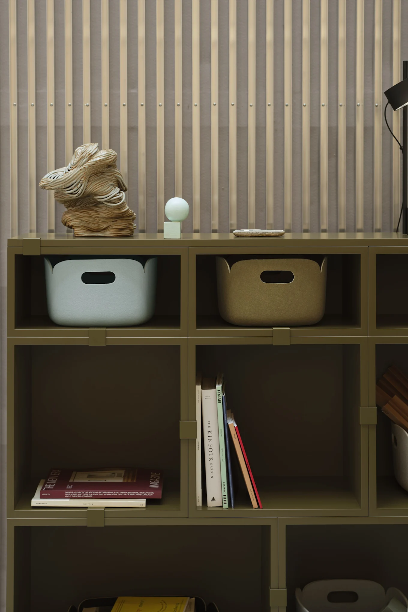 En grön hylla med förvaringslådor och böcker som detaljer, i linje med 2026 års inredningstrender.