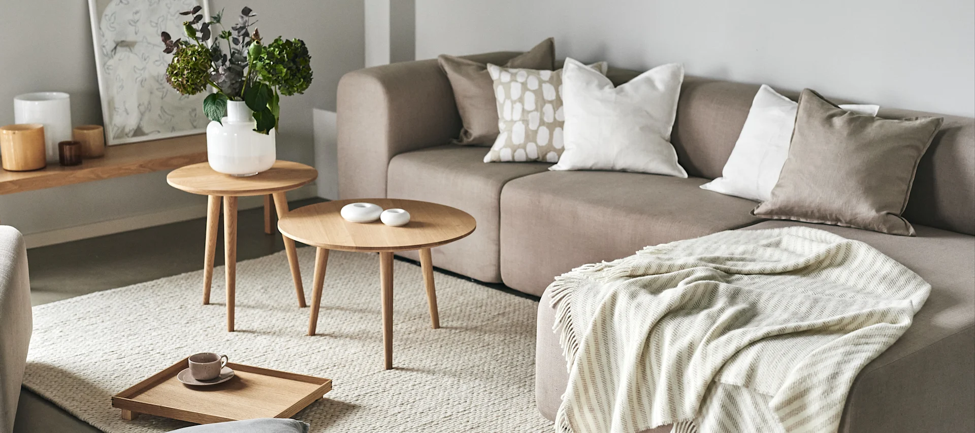 Skapa ett feng shui-vardagsrum genom att inreda ton-i-ton i en subtil färgskala, hålla ordning, och ha luftiga gardiner för att släppa in naturligt dagsljus.