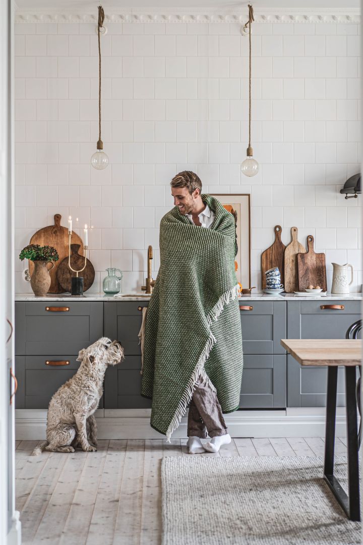 Instagram-profilen Hannes Mauritzson i sitt kök med sin hund Charlie i ett reportage för Nordic Nest. 